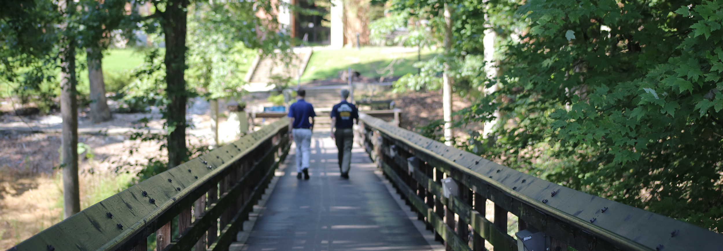 photo of two people crossing the footbridge to the Temple Building