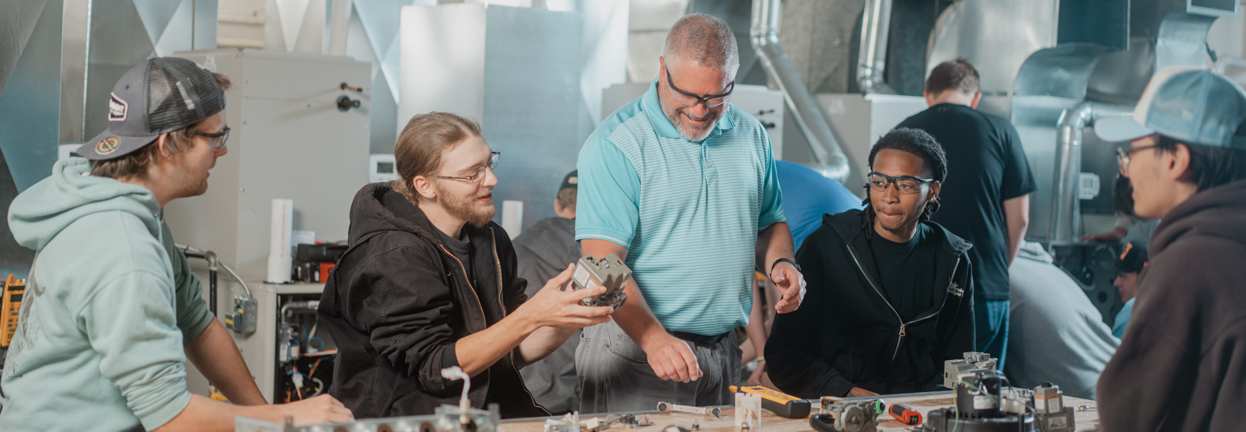Students in an HVAC class talking with professor.